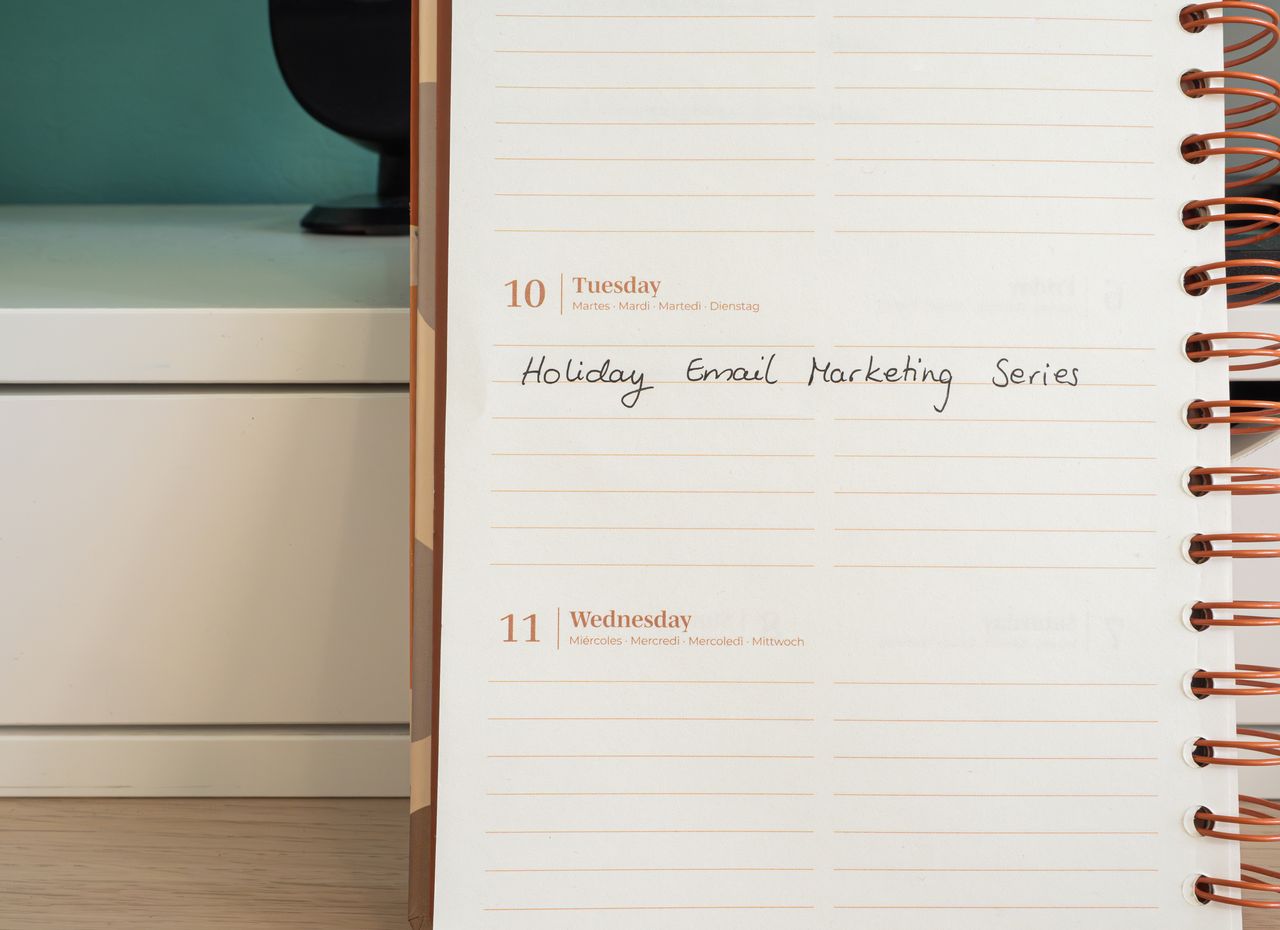 about-us-01 Planner open on a desk with handwritten Holiday Email Marketing Series note.